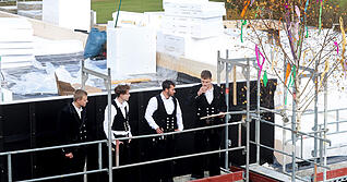 Jonathan Stein von Holzbau Amann (rechts) trägt den Richtspruch für den Anbau des Rathauses vor.
