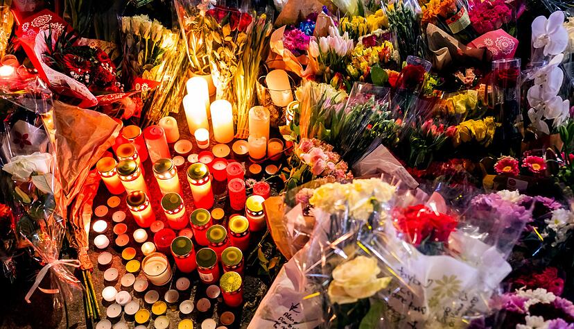 Ein Blumen- und Kerzenmeer erinnert an Tote und Verletzte in der N&auml;he des Brandortes.