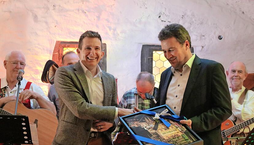 Bürgermeister Stefan Neumann (links) überreicht eine Aufnahme vom Barockschloss an Christian von Stetten.
Foto: Thomas Zimmermann