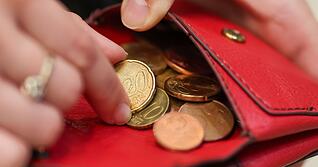 Eine Frau zählt Münzen.