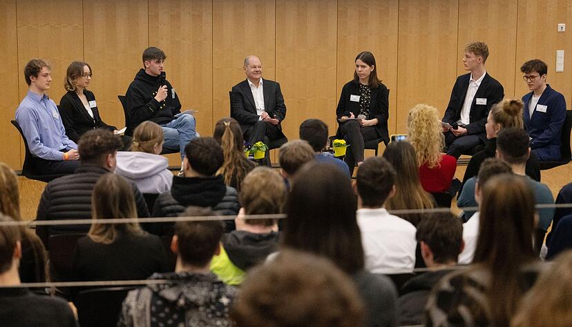 Bundeskanzler Olaf Scholz (SPD, hinten M) nimmt während eines Besuchs der Gottlieb-Daimler-Schule an einer Podiumsdiskussion teil.