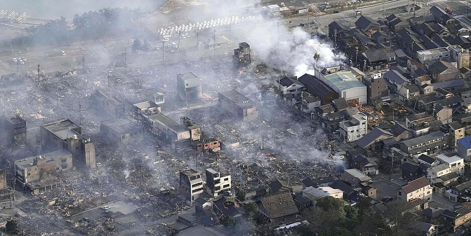 Nach dem Erdbeben in der Präfektur Ishikawa steigt Rauch aus dem Brandherd auf.
