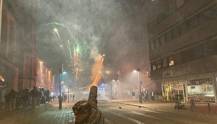 B&ouml;llerverbot mit F&uuml;&szlig;en getreten: Silvesternacht 2025/26 in der Heilbronner Kaiserstra&szlig;e. Ein junger Mann startet eine Rakete aus der Hand.