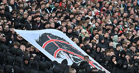 Hannover-Fans halten auf der Tribüne ein Plakat hoch, dass den Kopf von Niedersachsens Innenministerin Daniela Behrens in einem Fadenkreuz zeigt.