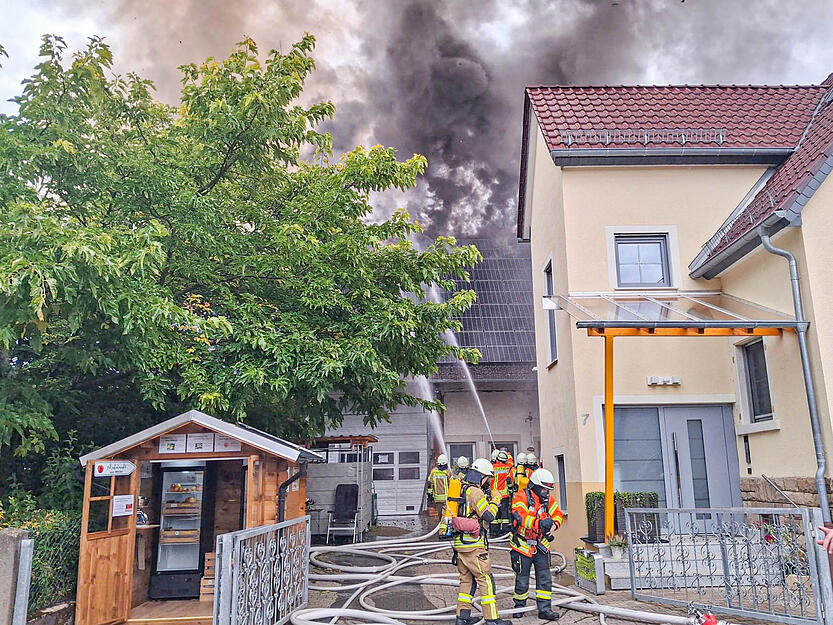 Eine Scheune in einem Hinterhof steht in Flammen.