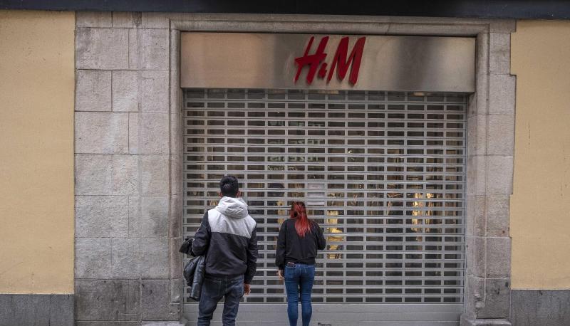 Passanten stehen vor einer geschlossenen H&M-Filiale. Passanten stehen vor einer geschlossenen H&M-Filiale.