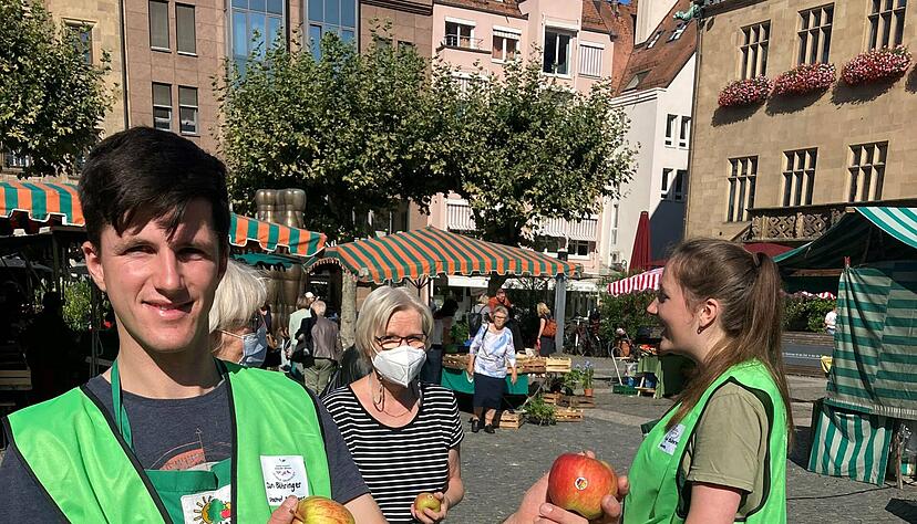 Jan B&ouml;hringer beim Verteilen von heimischen &Auml;pfeln an Marktkunden. 
 Foto: Friese