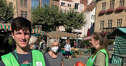 Jan B&ouml;hringer beim Verteilen von heimischen &Auml;pfeln an Marktkunden. 
 Foto: Friese