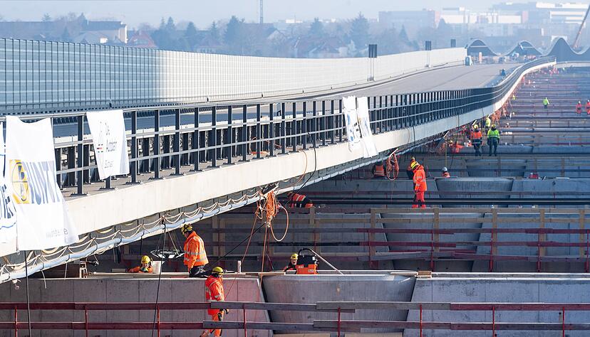 Emsige Handarbeit ist vor jeder Verschubetappe nötig: Auf Querachsen bereiten Arbeiter das Vorwärtsgleiten des nördlichen A6-Brückenteils über das Neckartal mit Teflonplatten vor.
Fotos: Mario Berger Emsige Handarbeit ist vor jeder Verschubetappe nötig: Auf Querachsen bereiten Arbeiter das Vorwärtsgleiten des nördlichen A6-Brückenteils über das Neckartal mit Teflonplatten vor.
Fotos: Mario Berger