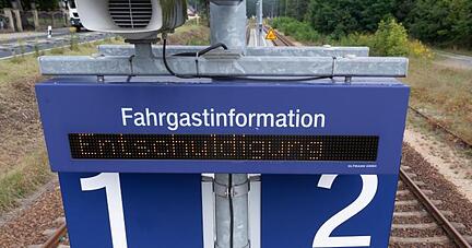 Das Wort "Entschuldigung" steht auf einer digitalen Anzeigetafel an einem Bahnsteig.