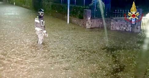 Italien, Brazzano di Cormons: Ein Feuerwehrmann steht nach Unwettern im Norden Italiens mit Überschwemmungen im Wasser. Italien, Brazzano di Cormons: Ein Feuerwehrmann steht nach Unwettern im Norden Italiens mit Überschwemmungen im Wasser.