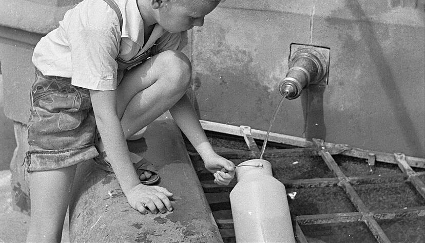 Ein Junge holt Wasser am Siebenröhrenbrunnen in den 60er Jahren Ein Junge holt Wasser am Siebenröhrenbrunnen in den 60er Jahren