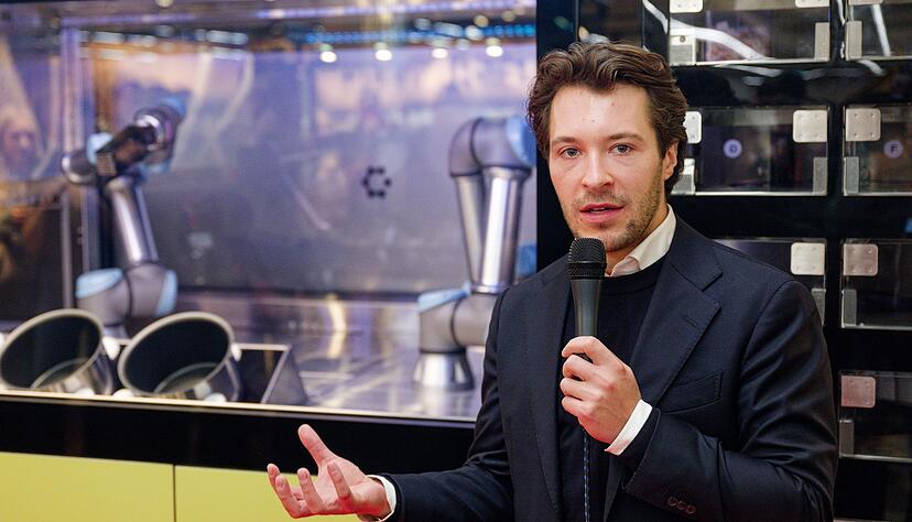 Circus-Gründer Bullwinkel spricht bei der Vorstellung des Kochroboters CA-1 in einem Rewe-Markt. (Archivbild)