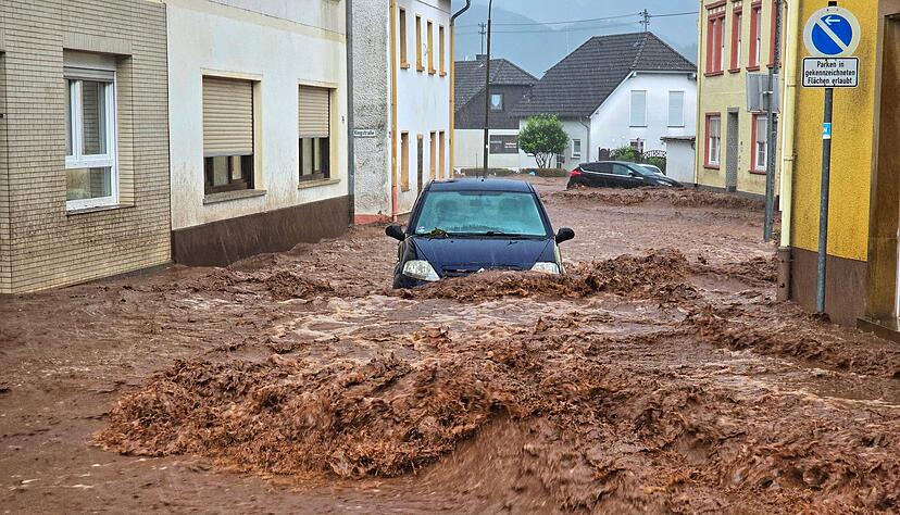 Ein Auto bahnt sich den Weg durch die Wassermassen in Kirn.