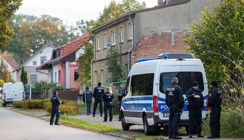 Polizisten stehen vor einem Grundstück in Herzberg.
