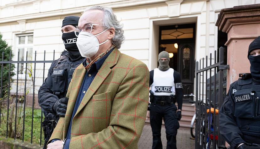 Bei einer Razzia gegen sogenannte Reichsbürger führen Polizisten Heinrich XIII Prinz Reuß (vorn) zu einem Polizeifahrzeug. (Archiv)