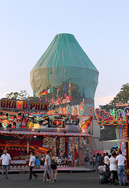 Der mächtige Hochbunker an der Theresienwiese ist 2014 kurz vor dem Start einer Betonsanierung mit Planen verhüllt. Das Volksfest zieht zahlreiche Besucher auf den Festplatz.