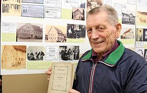 Josef Kruck mit einem Original-Exemplar der "Lehriaden". Eine Kopie des Fotos des Adlerwirts und Dichters Johann Lehr und seiner Frau ist neben einem Foto des alten Gasthauses "Adler" auch auf der Schautafel (li. unten) im Heimatmuseum zu sehen.