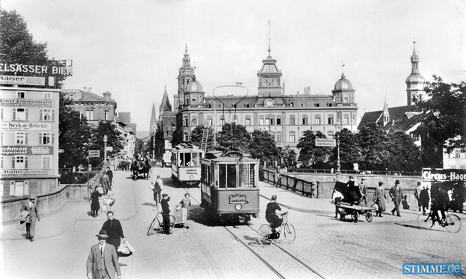 Reger Verkehr auf der Heilbronner Neckarbr&uuml;cke 1925: Fu&szlig;g&auml;nger, Stra&szlig;enbahn, Pferdegespann, Radfahrer und Handkarren queren.