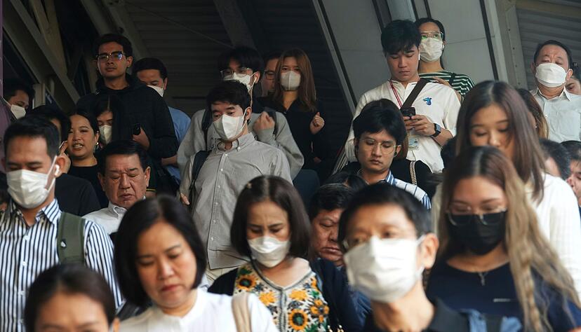 Pendler tragen Gesichtsmasken, um sich vor der Luftverschmutzung zu sch&uuml;tzen.