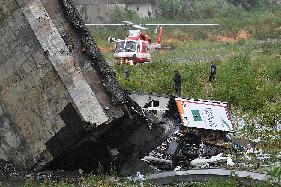 Rettungsarbeiten unter den Tr&uuml;mmern der eingest&uuml;rzten Morandi Autobahnbr&uuml;cke.
