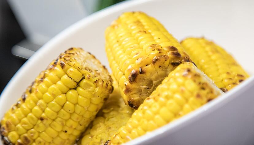 Den gefetteten und gesalzenen Mais sollte man beim Grillen zunächst nur indirekter Hitze aussetzen und erst zum Schluss noch einmal kurz direkt auf die Flamme geben.