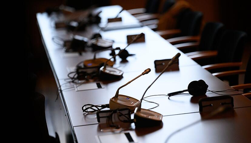 Mikrofone und Kopfhörer auf einem Tisch in einem Gerichtssaal. Mikrofone und Kopfhörer auf einem Tisch in einem Gerichtssaal.