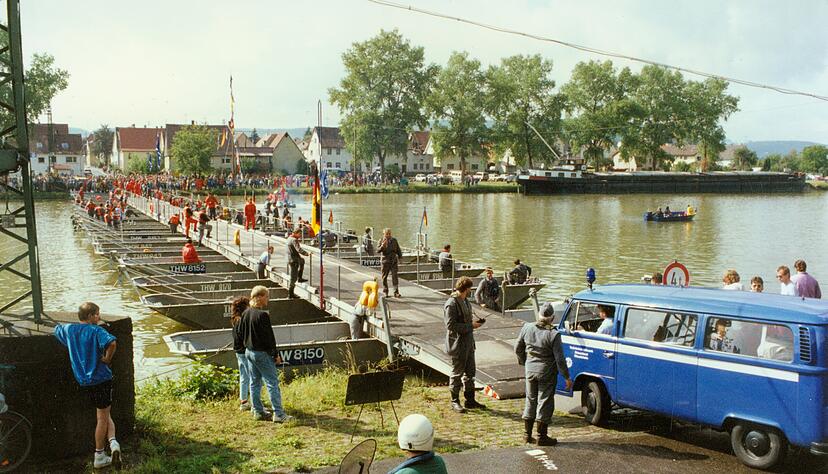 Das THW in Haßmersheim hält am Samstag, dem 7. Juni 2025 die Großübung „Brückenschlag“ ab. Schon im Jahr 1990 bauten Arbeiter eine begehbare Schwimmbrücke, wie alte Aufnahmen zeigen.
