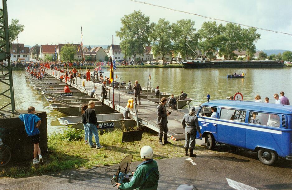 Das THW in Haßmersheim hält am Samstag, dem 7. Juni 2025 die Großübung „Brückenschlag“ ab. Schon im Jahr 1990 bauten Arbeiter eine begehbare Schwimmbrücke, wie alte Aufnahmen zeigen.