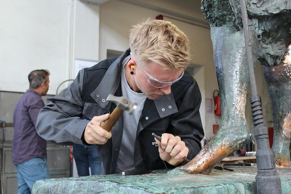 Metallbildner David Häderle gibt der frisch verschweißten Oberfläche den letzten Schliff.