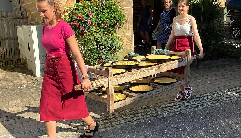 Zwölf Zwiebelkuchen, Peterlingkuchen und Rahmkuchen tragen Lina Jung und Thea Fromm zu den Festgästen zur Kelter. Zwölf Zwiebelkuchen, Peterlingkuchen und Rahmkuchen tragen Lina Jung und Thea Fromm zu den Festgästen zur Kelter.