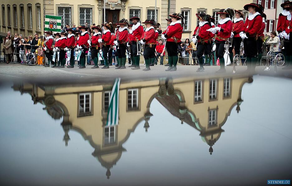 Salzsieder stehen am 24.05.2015 beim Salzsiederfest in Schw&auml;bisch-Hall (Baden-W&uuml;rttemberg) auf dem Marktplatz, w&auml;hrend sich im Vordergrund ein Haus in einer Wasseroberfl&auml;che spiegelt. &Uuml;ber Jahrhunderte produzierten die Salzsieder Salz - das "wei&szlig;e Gold des Mittelalters". Durch den damit verbundenen Handel wurde die Stadt wohlhabend. Seit dem 14. Jahrhundert ist in Schw&auml;bisch Hall das Salzsiederfest &uuml;berliefert. Foto: Daniel Naupold/dpa +++(c) dpa - Bildfunk+++