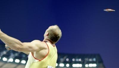 Robert Harting wirft den Diskus in Berlins dunklen Nachthimmel.