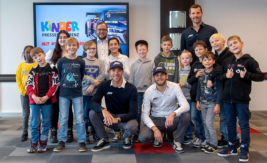 15 Nachwuchs-Reporter entlocken den DTM-Fahrern Ricardo Feller, Kelvin van der Linde und Ex-Sieger Martin Tomczyk bei einer Kinder-Pressekonferenz im Neckarsulmer Audi-Forum ungewöhnliche Antworten. Alexander Schnell aus der Chefredaktion der Heilbronner Stimme (hintere Reihe, Mitte) führte als Moderator durch die Pressekonferenz. 15 Nachwuchs-Reporter entlocken den DTM-Fahrern Ricardo Feller, Kelvin van der Linde und Ex-Sieger Martin Tomczyk bei einer Kinder-Pressekonferenz im Neckarsulmer Audi-Forum ungewöhnliche Antworten. Alexander Schnell aus der Chefredaktion der Heilbronner Stimme (hintere Reihe, Mitte) führte als Moderator durch die Pressekonferenz.
