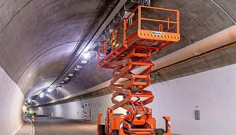 An der Decke des Stra&szlig;entunnels werden mithilfe einer Hebeb&uuml;hne Kofferlampen installiert.