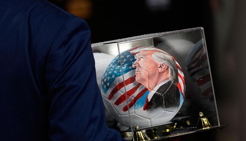 Vor der Auslosung ist auch ein Ball mit dem Gesicht von Trump zu sehen.