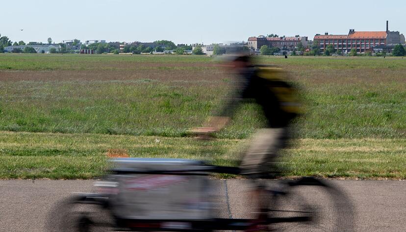 Ein Mann f&auml;hrt beim sonnigen Wetter auf einem Lastenrad.