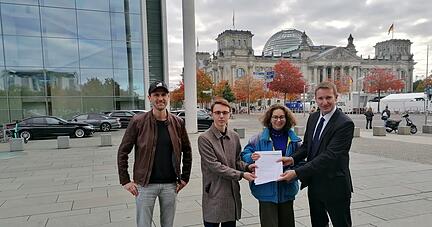 Von links nach rechts: Wolfgang Gründinger, Demokratieforscher, sowie Linus Steinmetz und Franziska Wessel, Klimaaktivisten von Fridays for Future, überreichen ihren Wahleinspruch an Patrick Sensburg (CDU), Vorsitzender des Wahlprüfungsausschusses des Deutschen Bundestags. Foto: Deglow