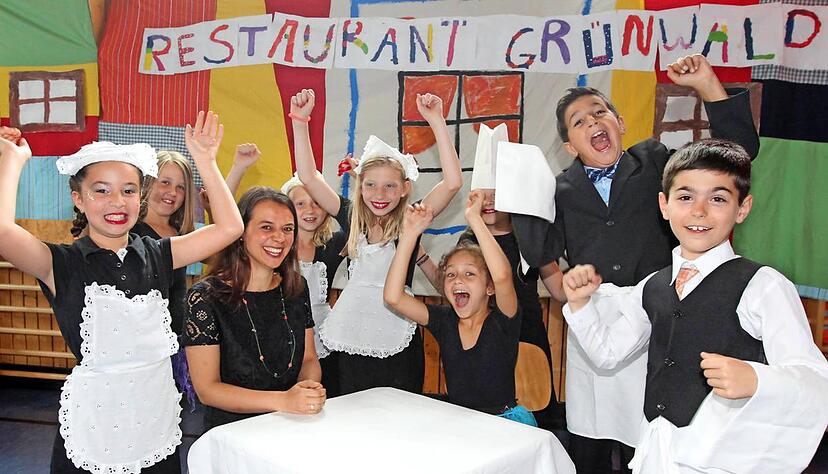 Hallo! Die jungen Kellner vom Schulzirkus bejubeln Schulleiterin Eva Happold im Restaurant Grünwald. Foto: Andreas Veigel