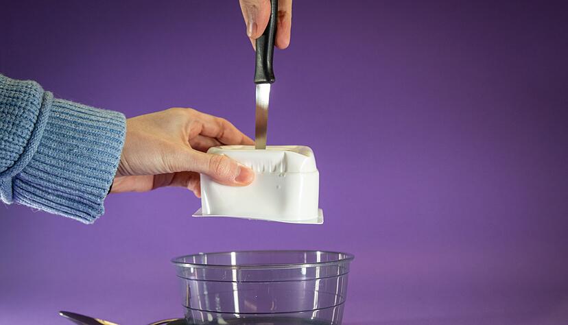 Schritt 1: Quarkbecher umdrehen und mit einem Messer von oben einstechen.