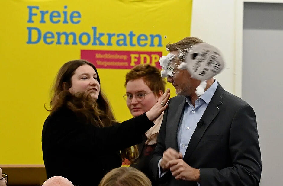 Der FDP-Vorsitzende Christian Lindner bekommt bei einem Wahlkampfauftritt in Greifswald Schaum ins Gesicht.