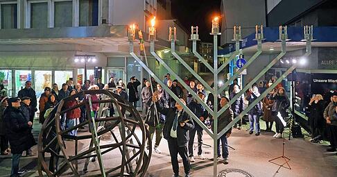 Chanukka-Feier an der Heilbronner Allee: Rabbiner Mark Pavlovsky entz&uuml;ndet am Montagabend die ersten Lichter des vier Meter gro&szlig;en Leuchters.