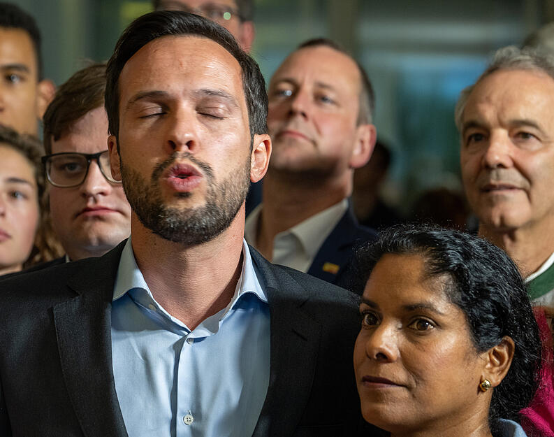 Martin Hagen (FDP), Landesvorsitzender Bayern, sieht sich mit seiner Ehefrau Anisha bei der Wahlparty der FDP im Restaurant Ella die Prognosen an.
