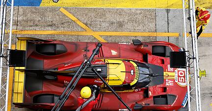 Mechaniker betanken das Auto des Teams Ferrari.