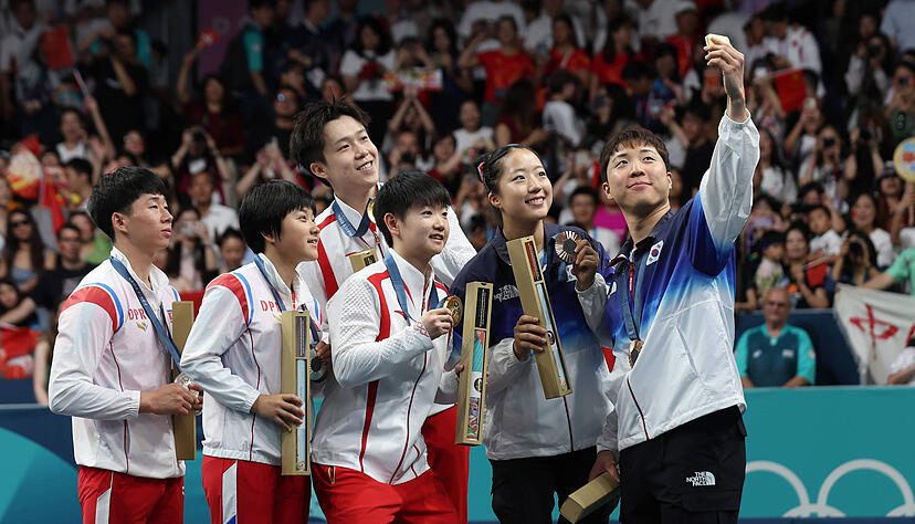 Ein Selfie mit Strahlkraft nach dem Mixed-Wettbewerb im Tischtennis: Südkoreas Lim Jonghoon fotografiert sich mit den Kontrahenten aus China und Nordkorea.