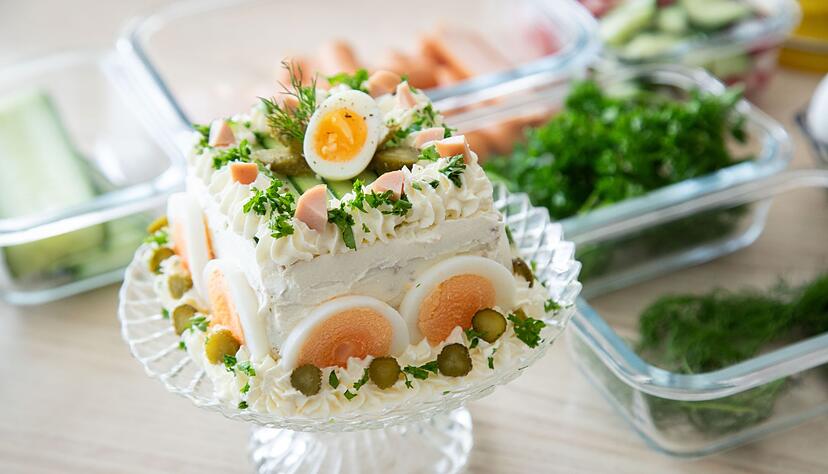 Cornichons, gekochte Eier-Scheiben und Frischkäse dienen der Brottorte als Verzierung. Cornichons, gekochte Eier-Scheiben und Frischkäse dienen der Brottorte als Verzierung.