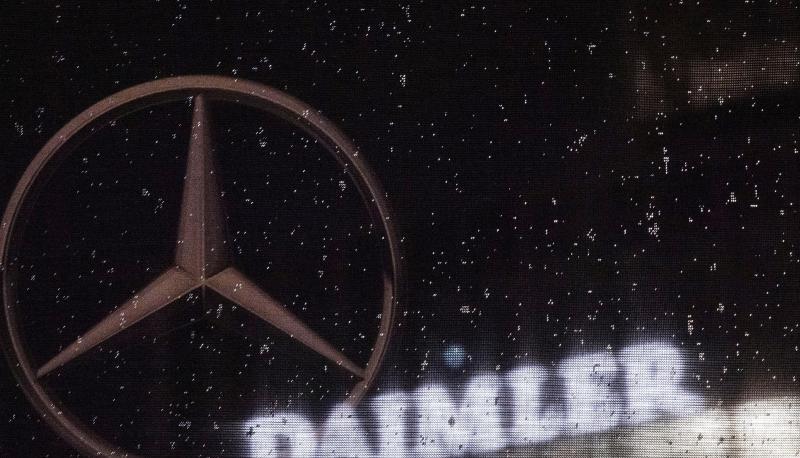 Das Daimler-Logo an der Konzernzentrale in Stuttgart, davor eine Flagge mit dem Mercedes-Stern.