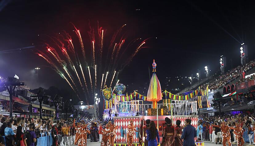Mehrere Sambaschulen ziehen mit bunten Wagen durch die Stra&szlig;e.