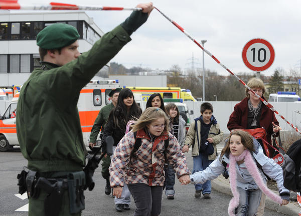 Wenige Minuten nach dem brutalen Verbrechen f&uuml;hren Polizisten traumatisierte M&auml;dchen und Jungen aus dem abgesperrten Schulzentrum. Besorgte Eltern wollen wissen, wie es ihren Kindern geht.