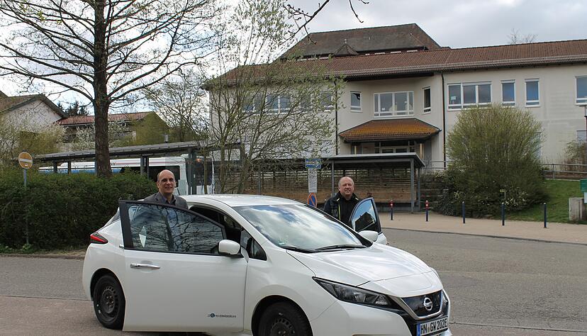 Bürgermeister Timo Wolf (links) und Energiebeauftragter Thomas Löffelhardt stehen mit dem E-Fahrzeug auf dem Teilbereich des Schulparkplatzes, wo der E-Carsharing-Bereich hinkommt.
Foto: Sabine Friedrich